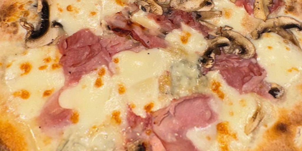 Une pizza Della Mama sortie du four à bois
