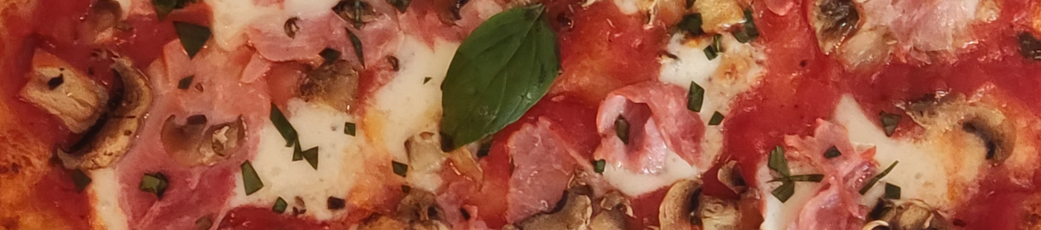 Gros plan sur une Regina : mozzarella, jambon, champignons, basilic
